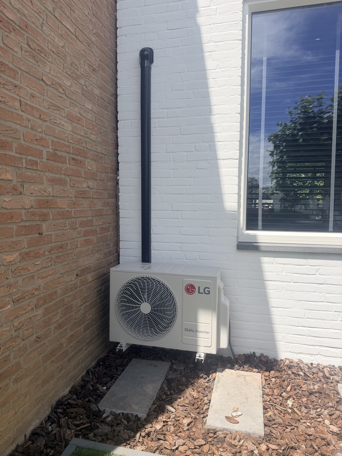 Netjes afgewerkte LG buitenunit met zwarte leidinggoot
